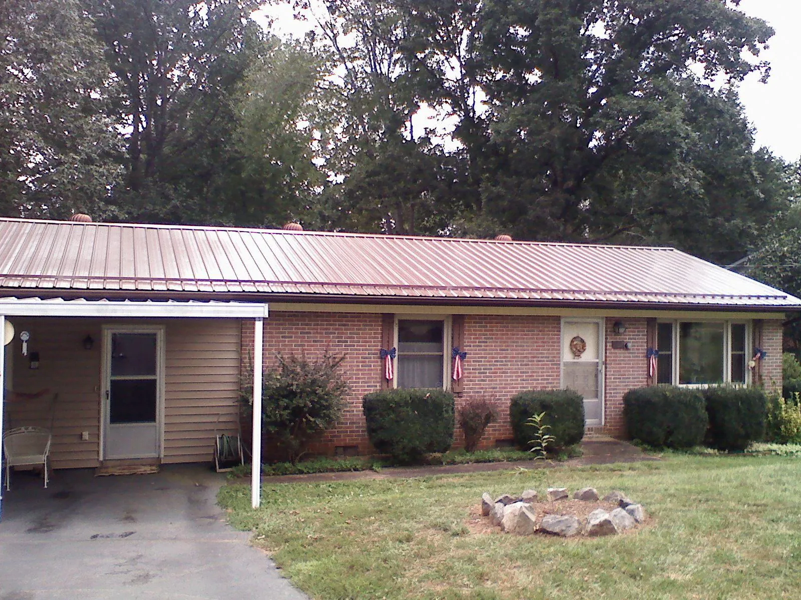 Bronze metal roof and carport on a brick ranch home — Roof Repair work by our crew in Lynnville